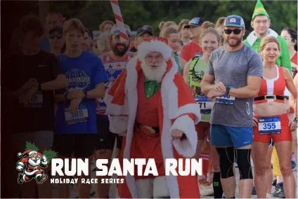 Runners in festive holiday costumes, including Santa Claus and an elf, at the start line of the Run Santa Run Holiday Race Series.