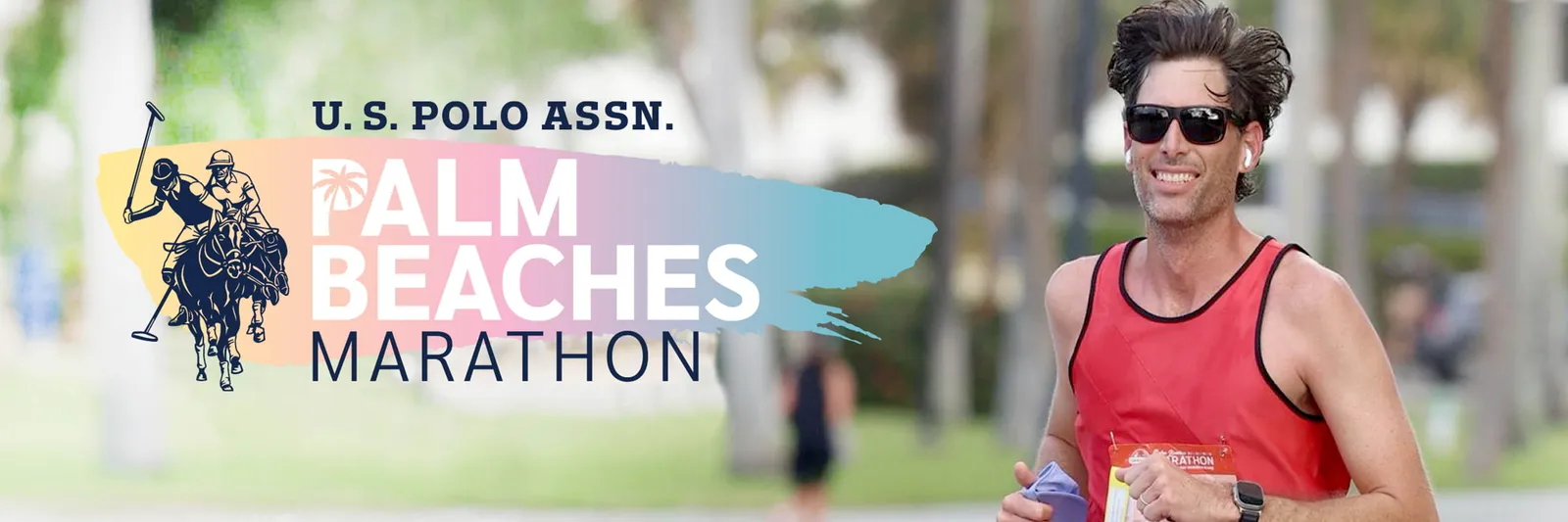 A smiling male runner in a red tank top runs during the U.S. Polo Assn. Palm Beaches Marathon, with race branding on the left.