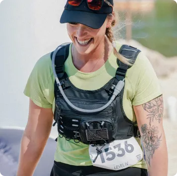A female runner with a bib number 1536 smiles as she runs.