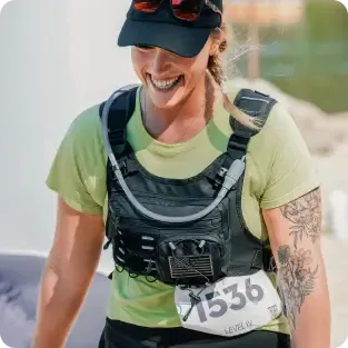 A smiling female runner wearing a hydration vest and a race bib with the number 1536.