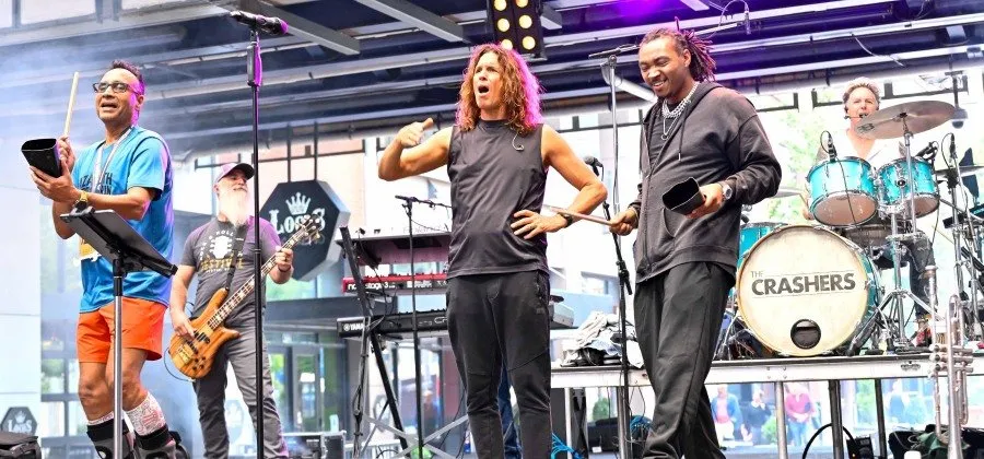 A band performing on stage, with musicians playing instruments and singing.