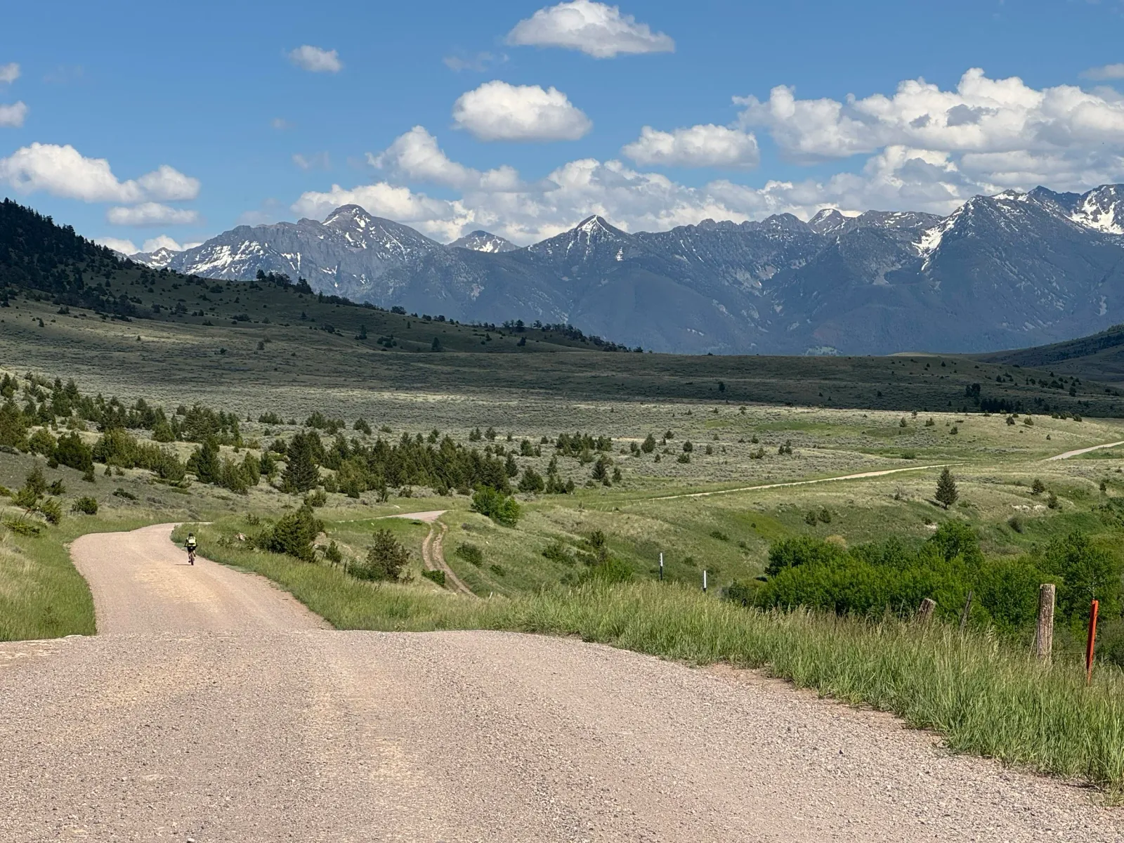 A solo runner on a dirt road with a scenic mountain backdrop.