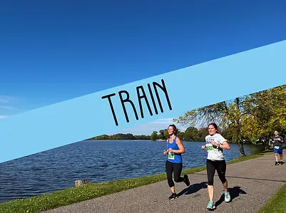 Two women running on a paved path next to a lake, with a blue banner overlaying the top of the image with the word 'TRAIN'.