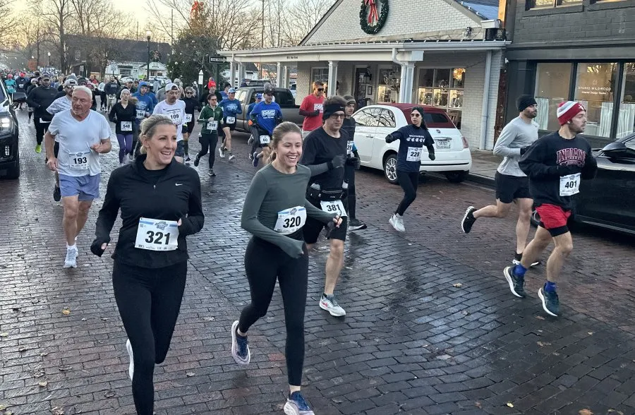 Runners participating in the Zionsville Half Marathon and 5K race, with bib numbers visible.