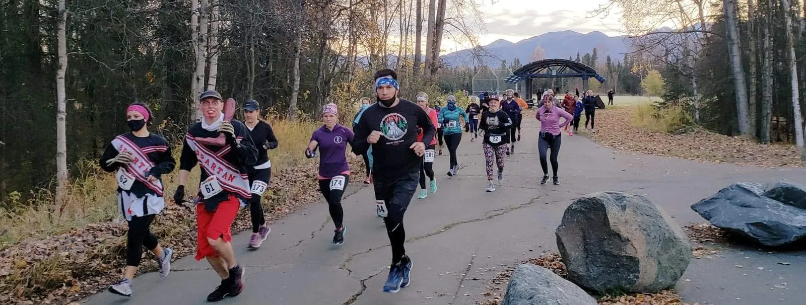 A group of runners participating in the Zombie Half Marathon, with mountains in the background.